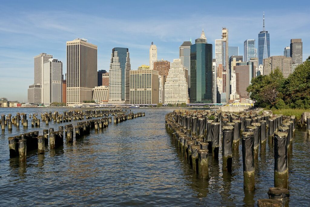 Lower Manhattan skyline seen over old pier pilings from Brooklyn Bridge Park