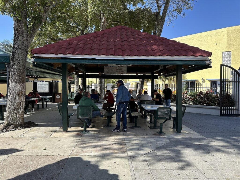 People gathered beneath a pavilion at Domino Park in Little Havana