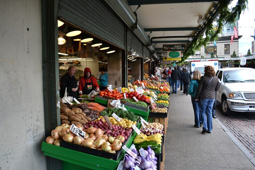 Produce stalls along the covered sidewalk at Pike Place Market