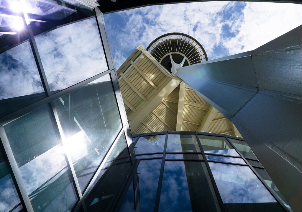 Space Needle viewed upward beside a glass structure at Seattle Center